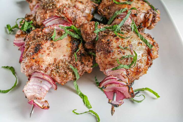 za atar grilled chicken thighs, Za atar Grilled Chicken Thighs on a white serving platter garnished with fresh mint