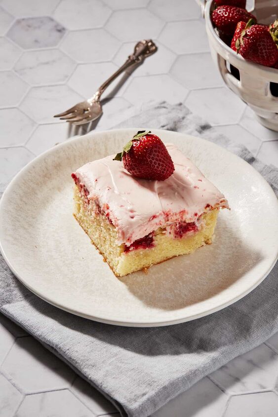 strawberry jam cake with cream cheese frosting, Strawberry Poke Cake on a plate with a fork and strawberry