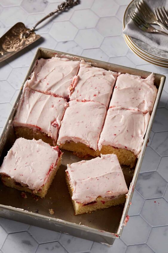 strawberry jam cake with cream cheese frosting, A cake pan with strawberry cake cut into slices