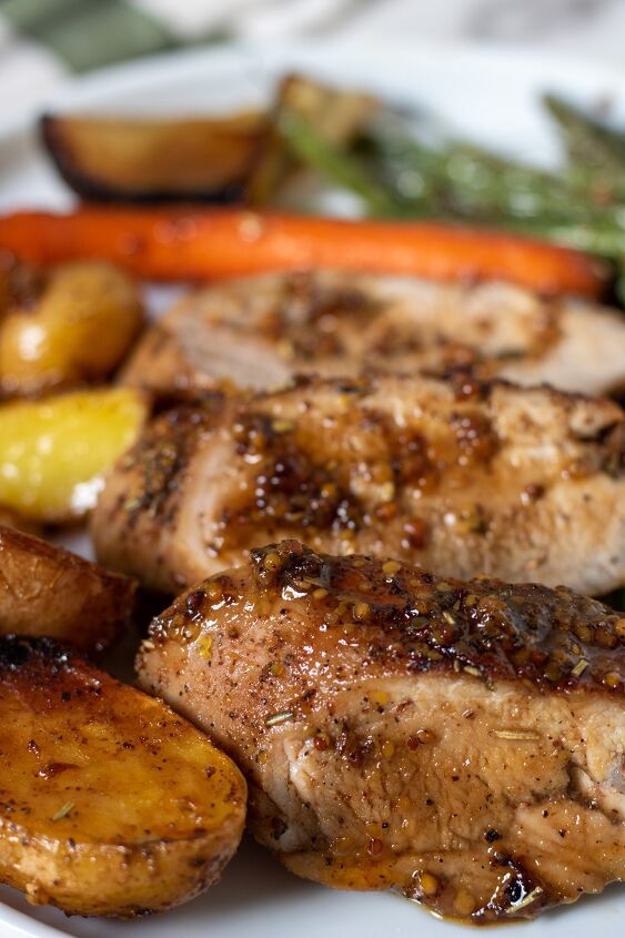 honey mustard roasted pork tenderloin with potatoes and carrots, Sliced pork tenderloin pieces with honey mustard glazed You can see oven roasted potatoes carrots and green beans on the white plate There s a fork in the background