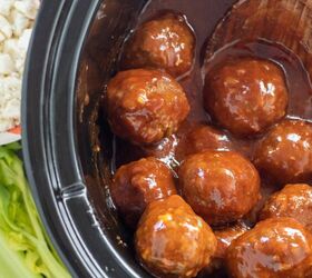 crockpot buffalo bbq chicken meatballs, A black crockpot filled with buffalo bbq chicken meatballs There s celery and blue cheese crumbles in the background
