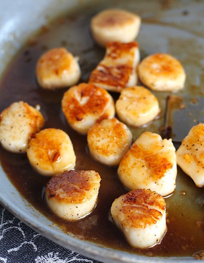quick glazed pan seared scallops with garlic, Glazed Pan Seared Scallops with Garlic and Honey in a pan with spatula