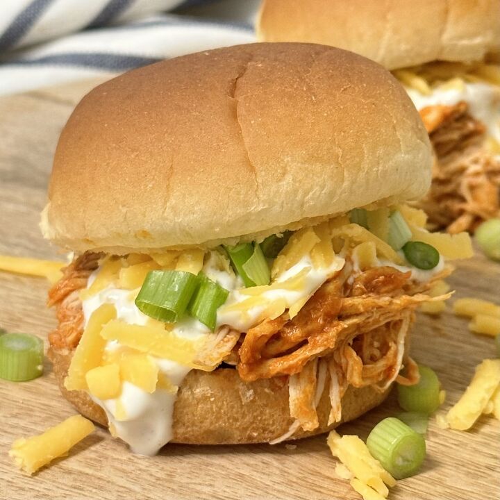 slow cooker buffalo chicken sliders, Close up of a slow cooker buffalo chicken slider with all the toppings