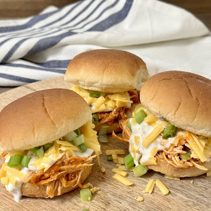 slow cooker buffalo chicken sliders, Slow Cooker Buffalo Chicken Sliders topped with ranch dressing cheddar cheese and sliced green onions