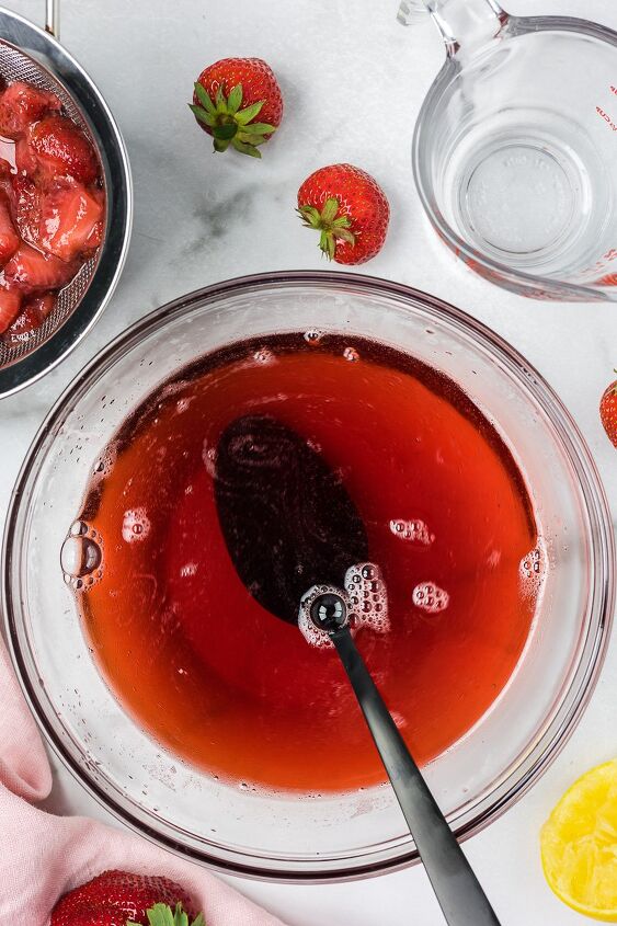 strawberry simple syrup, Strawberry simple syrup in a clear bowl with a black spoon