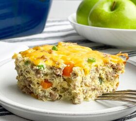 easy cheesy sausage egg bake, piece of sausage egg bake on a white plate with casserole dish and green apples in background