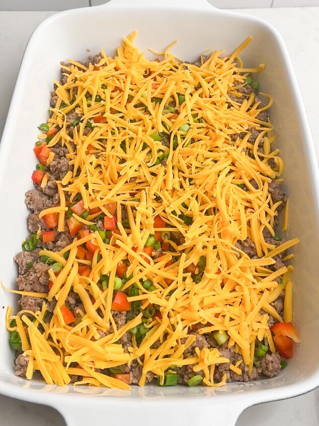easy cheesy sausage egg bake, sausage onions peppers and cheese in casserole dish