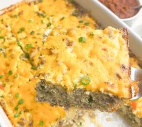 easy cheesy sausage egg bake, spatula with one slice of egg bake with casserole dish of egg bake in background