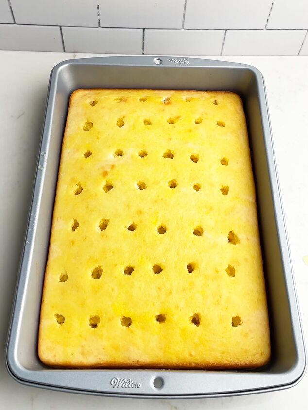 lemon poke cake, white cake with holes poked on top and lemon jello poured over the top