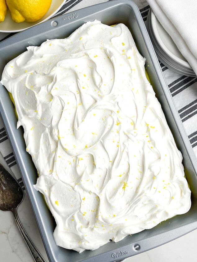 lemon poke cake, lemon poke cake in a 9 x 13 pan on black and white napkin