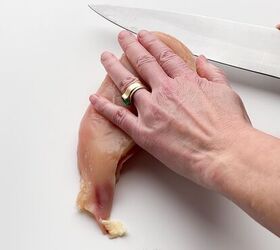 crispy baked thin chicken breasts, hand holding chicken breast flat and slicing it with a knife