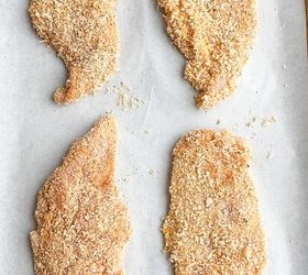 crispy baked thin chicken breasts, panko thin sliced chicken on parchment lined baking sheet