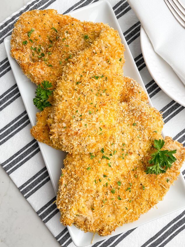 crispy baked thin chicken breasts, baked thin sliced chicken with panko on white platter on black and white napkin