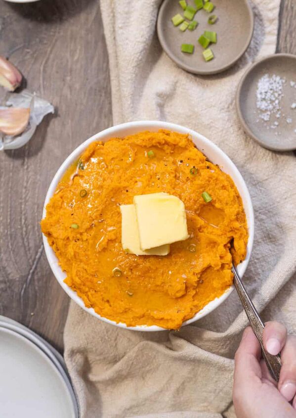 the perfect mashed butternut squash sweet potato, butternut squash sweet potato mash in a bowl with butter on top on a wood surface with a tan napkin