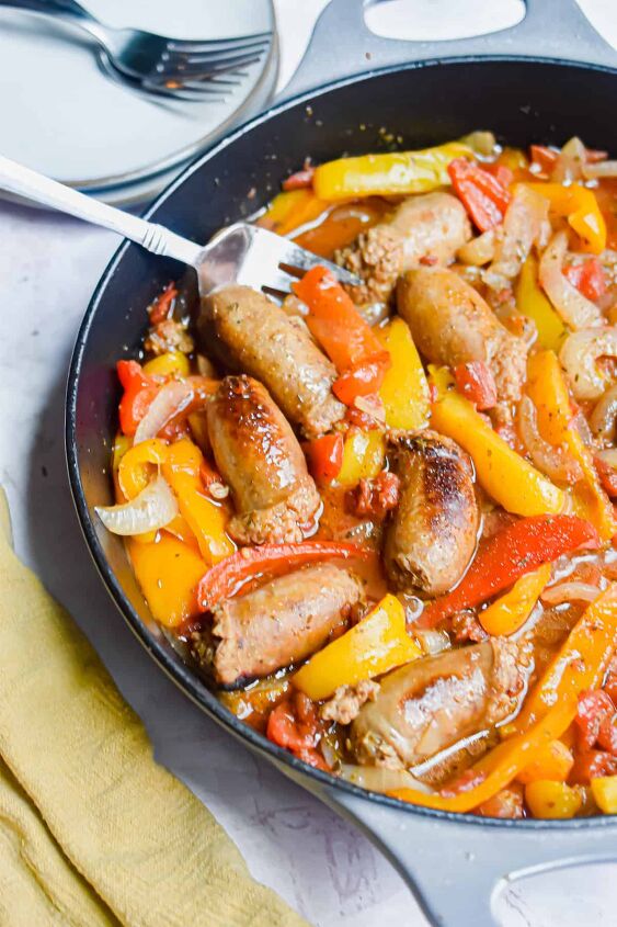 one pot sausage and peppers, A fork is in the pan with the one pot sausage and peppers and a yellow napkin on the corner of the pan