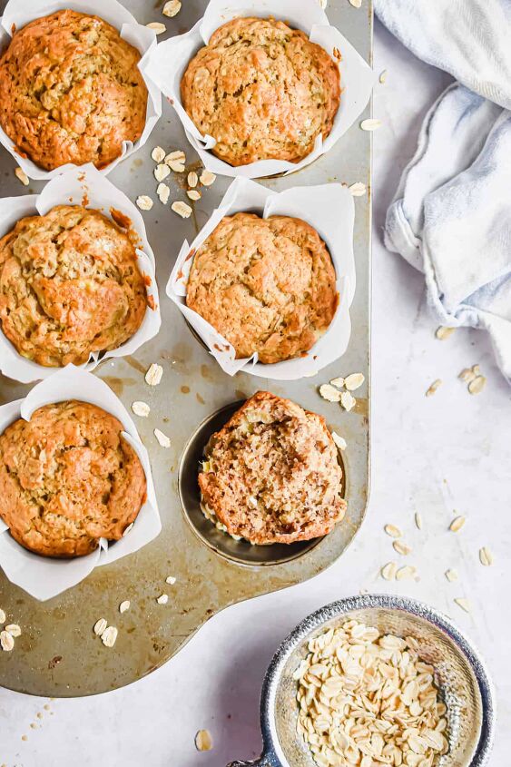 easy banana oatmeal muffins, One banana oatmeal muffin is in a muffin tin with whole muffins in the other tins