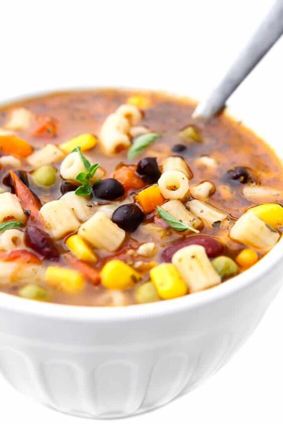 vegan minestrone soup, A white bowl filled with vegetarian minestrone soup with a spoon in it