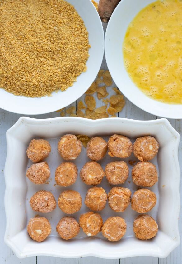 air fryer goat cheese sweet potato bites, A rectangle white baking dish filled with sweet potato goat cheese balls There s a white bowl with corn flake crumbs and a bowl with beaten eggs
