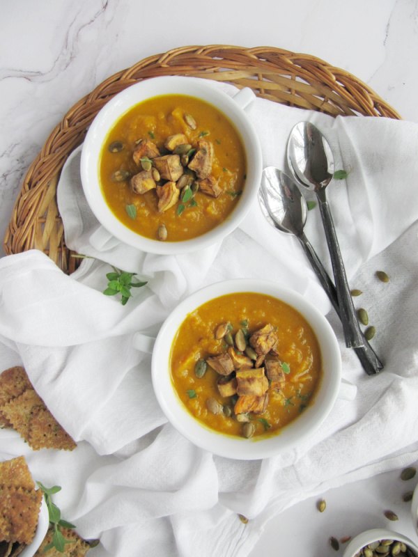 sweet potato and pumpkin soup, Spicy Sweet Potato and Pumpkin Soup in two white bowls on a rattan tray with two spoons