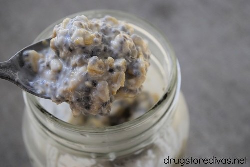 A spoon lifting overnight oats out of a mason jar