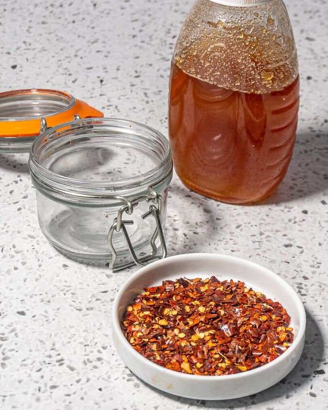 homemade hot honey, white dish with red pepper flakes jar of honey and flip top mason jar