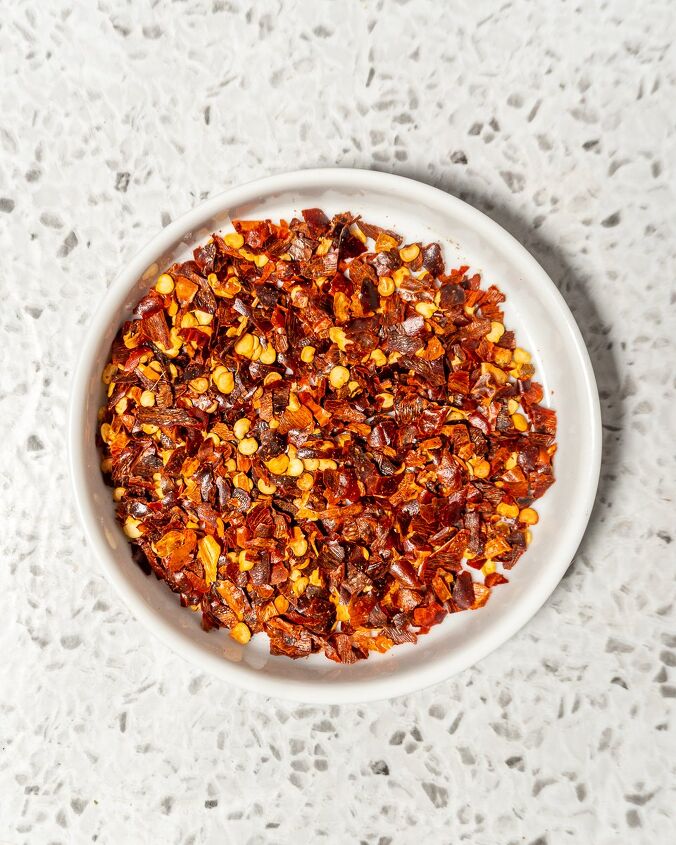 homemade hot honey, round shallow white dish with crushed red pepper flakes