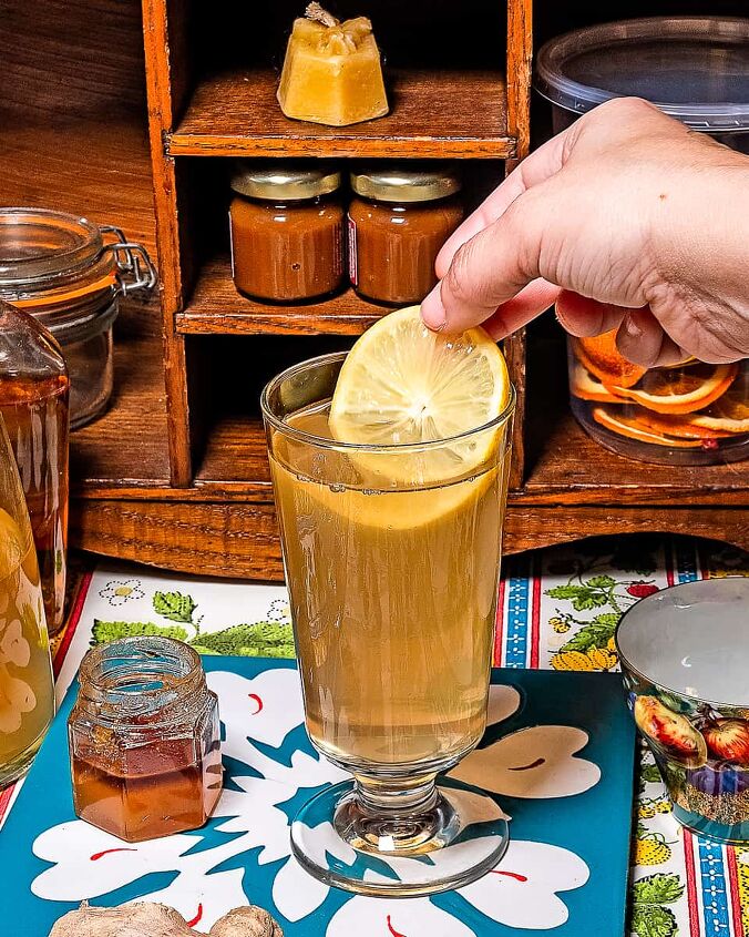 ginger water, Person placing a in lemon slice into a glass of Ginger infused water