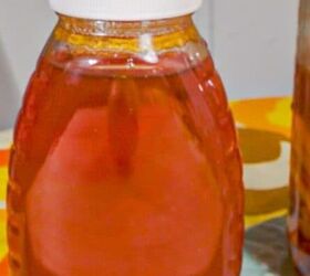 honey fermented ginger, bottle of honey and mason jar on lemon slices in fermented honey