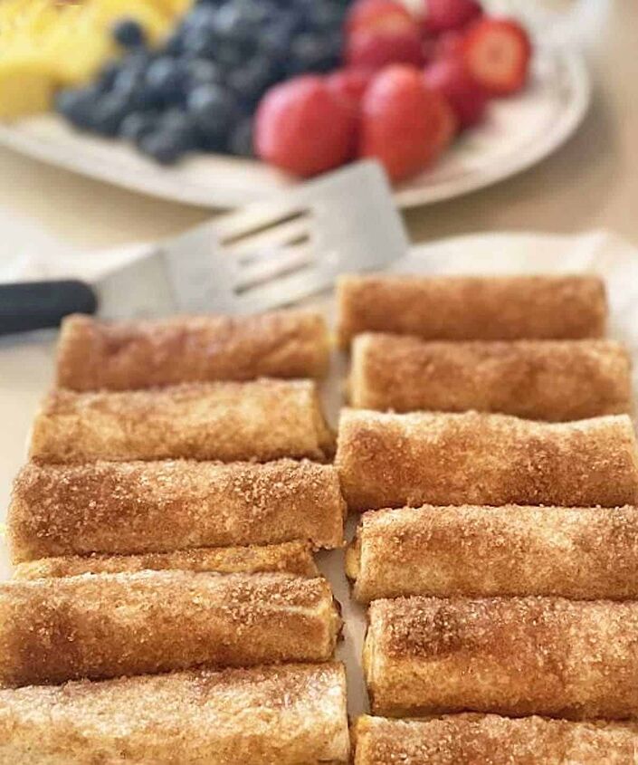 cinnamon cream cheese roll ups, Ten cream cheese roll ups on a serving tray with fresh fruit in the background
