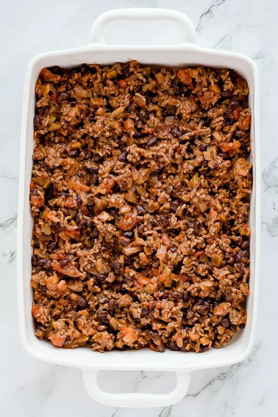 walking taco casserole with doritos, Meat mixture spread in bottom of white baking dish
