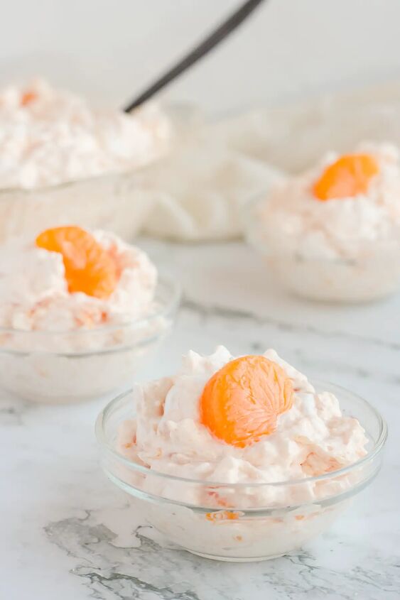 orange jello salad with cottage cheese, Small glass bowls of salad on countertop with mandarin orange slices on top