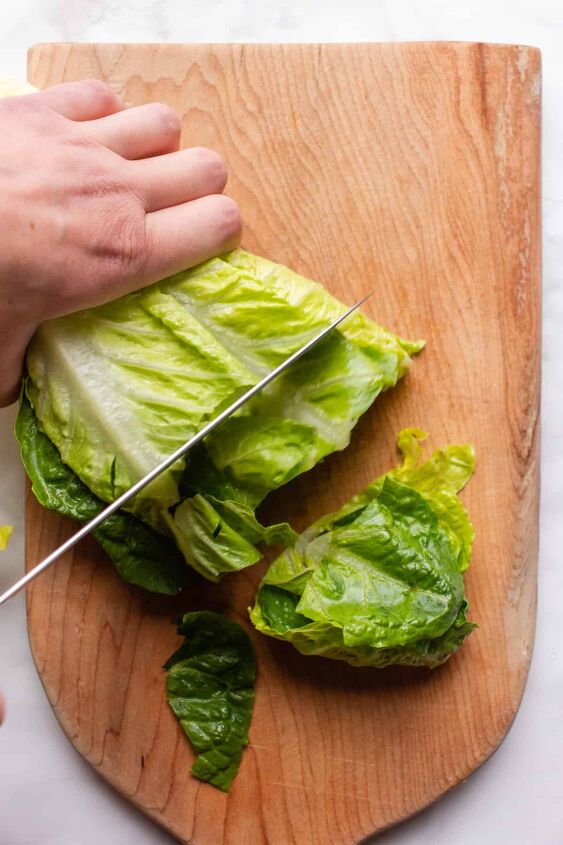 crowd pleasing vegan caesar salad you won t believe it s dairy free, Chopping romaine lettuce on a large wooden board