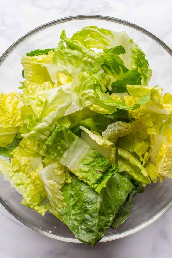 crowd pleasing vegan caesar salad you won t believe it s dairy free, Adding chopped Romaine Lettuce to a large glass bowl