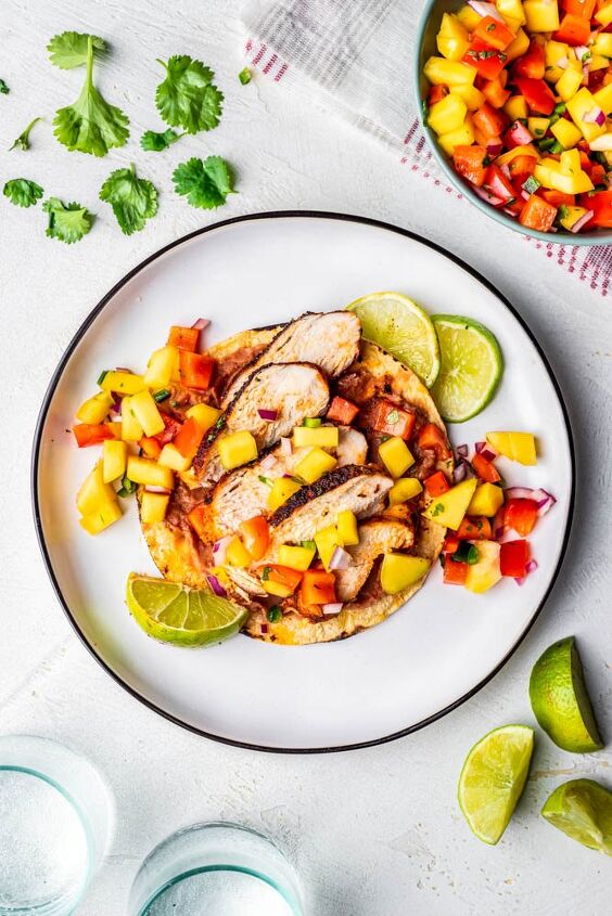 blackened chicken tacos with mango salsa, One blackened chicken taco on a white plate with refried beans and mango salsa