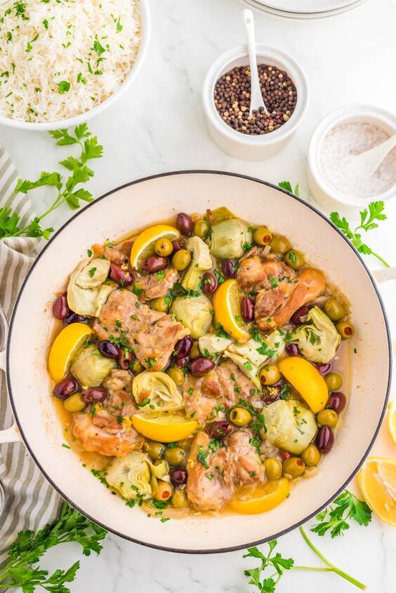 easy greek chicken thighs, Greek chicken thighs in a pan with olives lemons and artichoke hearts