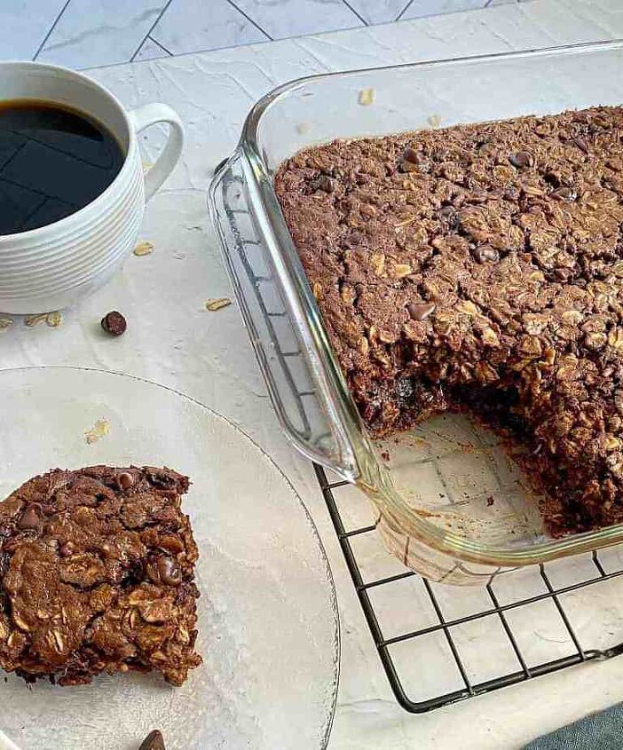 chocolate baked oatmeal happy honey kitchen, A serving of chocolate baked oats is on a plate with a fork while a glass baking dish on a cooling rack has the remaining baked oatmeal
