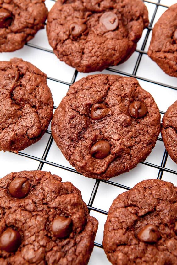vegan chocolate cookies, Fudgy vegan chocolate cookies on a wire rack on a white countertop