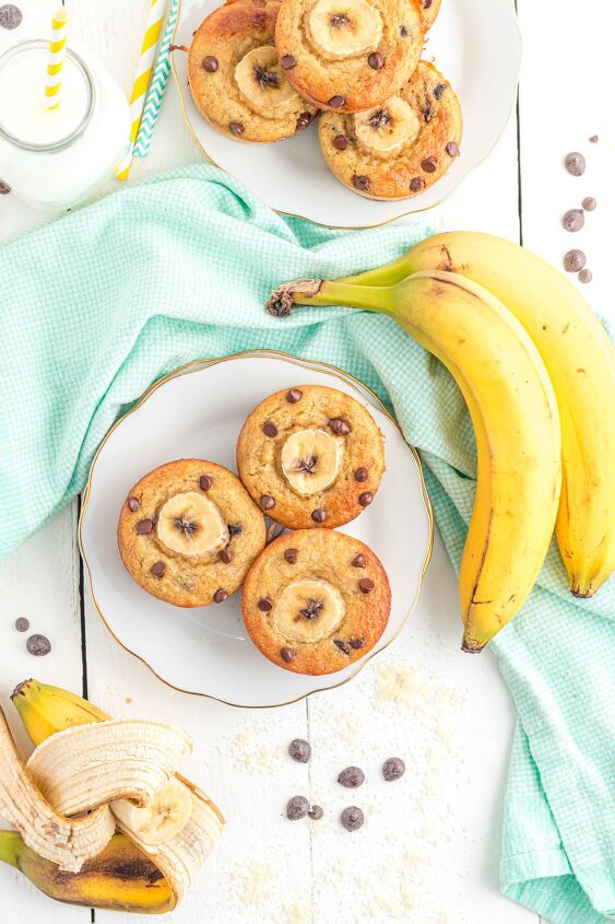 banana muffins with almond flour, Plates of banana chocolate chip muffins on a plate with bananas and chocolate chips sprinkled around