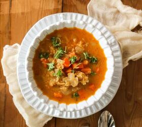 vegan moroccan red lentil soup recipe gluten free, bowl of moroccan red lentil soup with two spoons and a citrus juicer