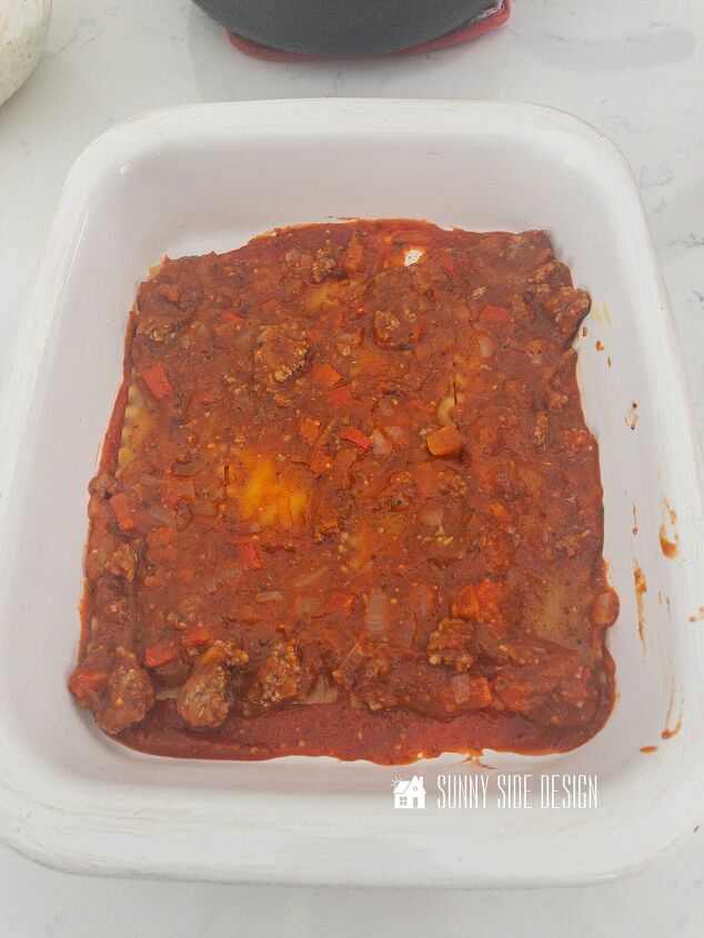 how to make the best lasagna with meat sauce, First layer of meat sauce is placed over the dry lasagna noodles