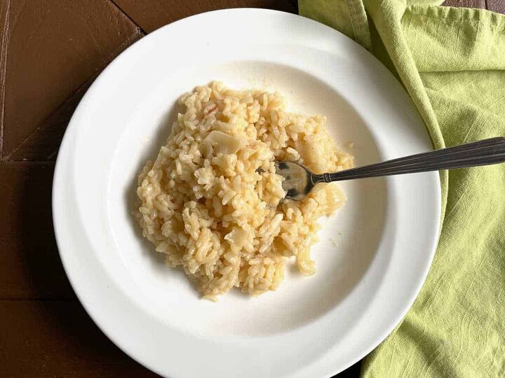 how to make risotto the traditional italian recipe, Traditional Italian risotto on a white plate with a green napkin