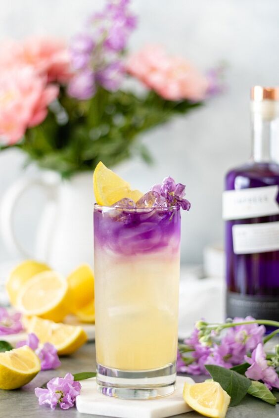 honey lavender gin lemonade with empress, A glass of fresh lemonade sitting on a marble trivet topped with a splash of Empress 1908 Gin