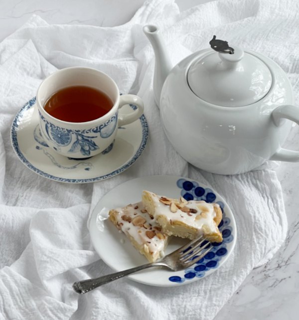 almond kringle, Almond Puff Pastry Swedish Kringler on a blue and white plate with a cup of tea and w white teapot