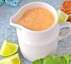 cashew queso easy 3ingredient vegan dip, Southwest Dressing in White Pitcher on concrete counter with limes cilantro spices and blue print fabric