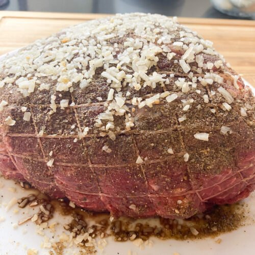 best beef roast with roasted veggies, beef roast with rub and minced onions ready to go into the oven