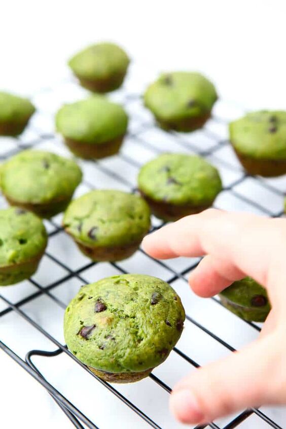 spinach muffins healthy hulk muffins, Green mint chocolate chip muffins on a cooling rack with a kid s hand reaching for one