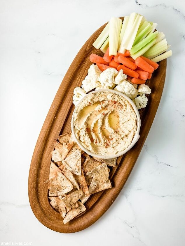 homemade hummus and pita chips sheri silver, hummus on a wooden board with pita chips and crudite
