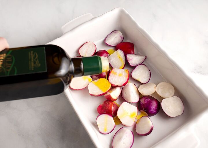 roasted herbed radishes, Pouring olive oil on radishes in the baking pan