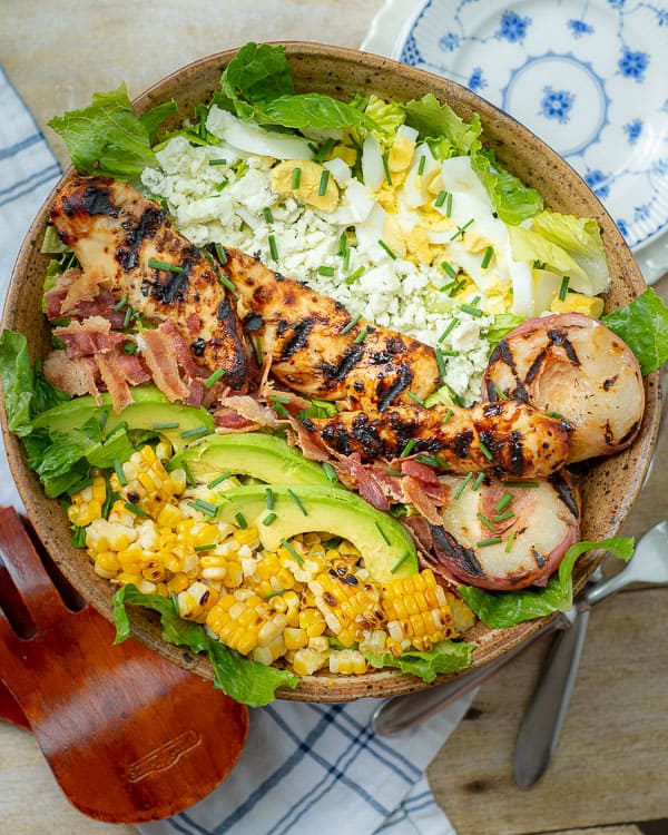 grilled chicken salad, overhead shot of grilled chicken salad with plates nearby