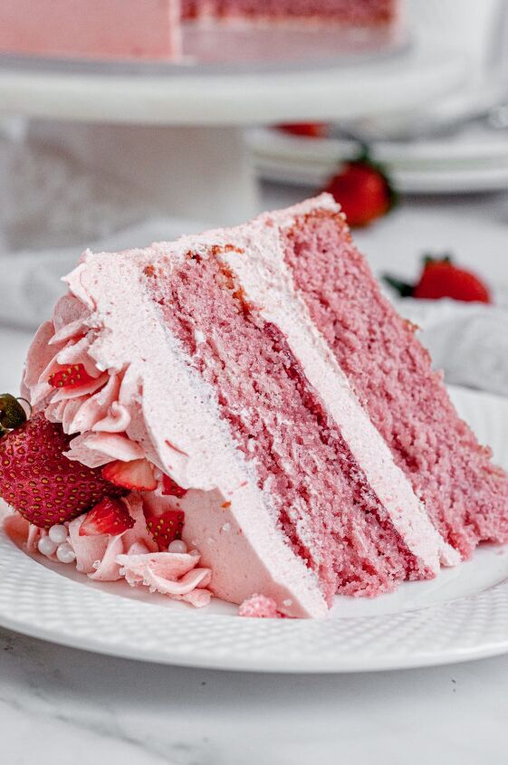 gluten free strawberry cake dairy free, A slice of pink strawberry cake sitting on a white plate It is topped with fresh red strawberries and covered in light pink frosting